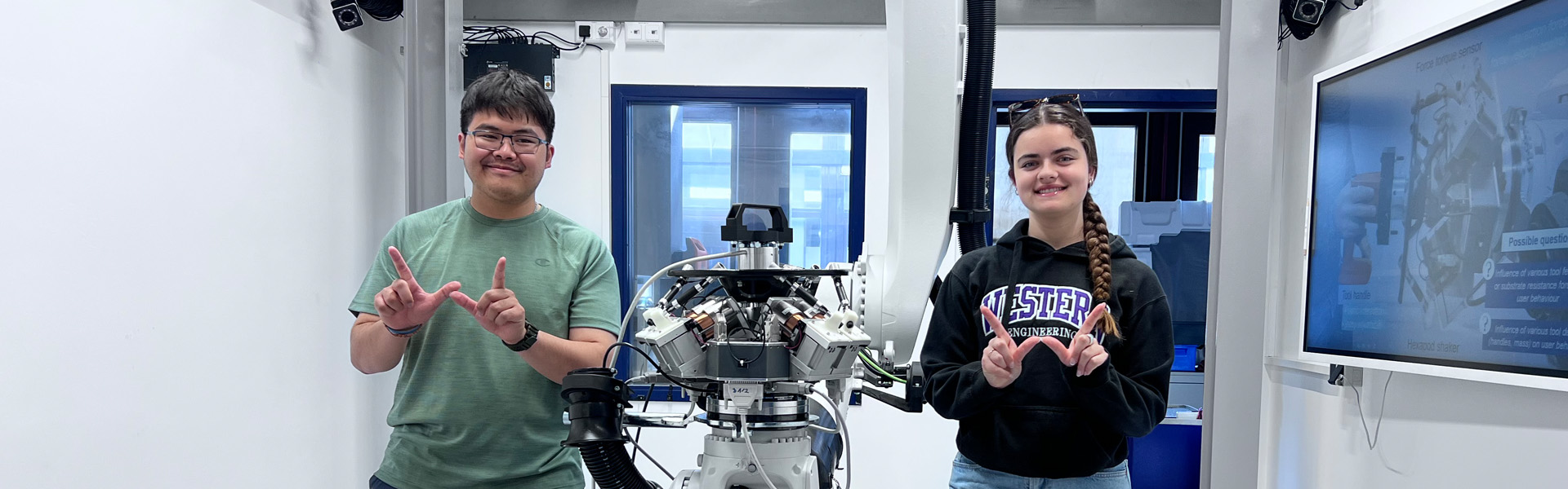 Students standing with a robot between them