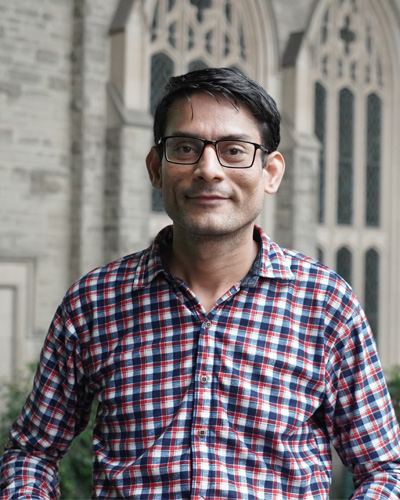 Dharma smiling with a stone wall in the background