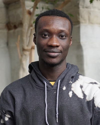 A male student smiling outdoors on campus