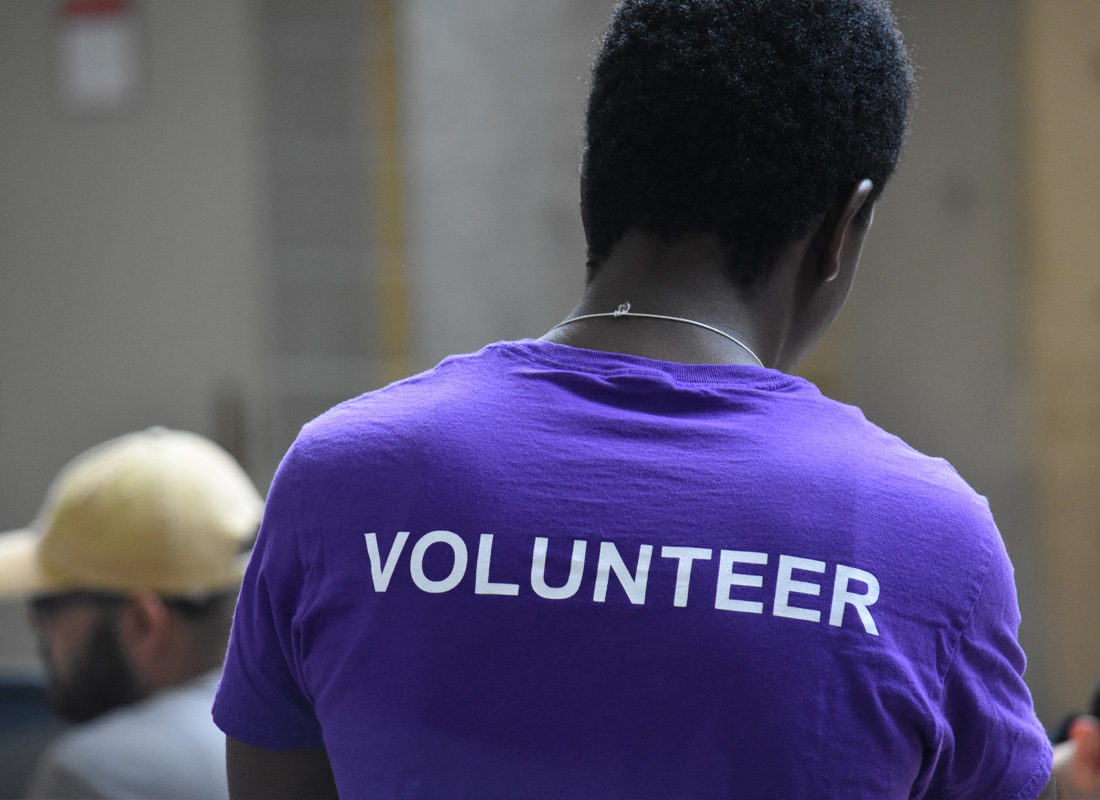 A man standing in a shirt that says "volunteer"