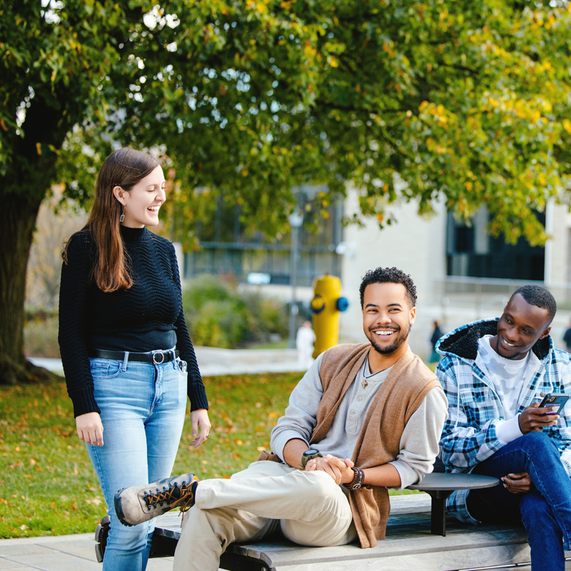 Students laughing together at a table outside the IGAB