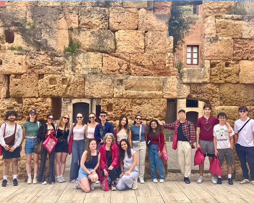 Students in front of an old style rock building.