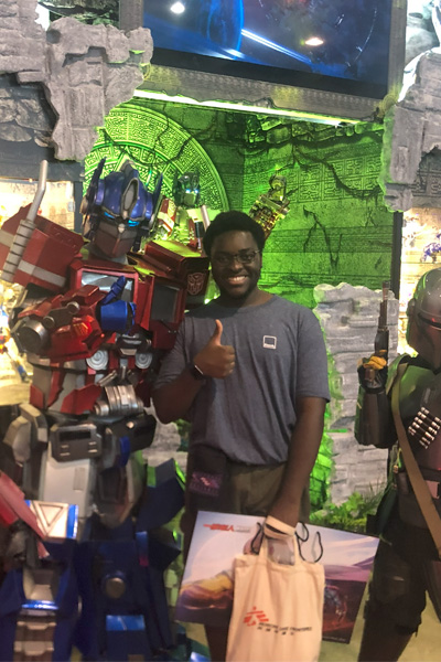 Koby standing with Optimus Prime and smiling