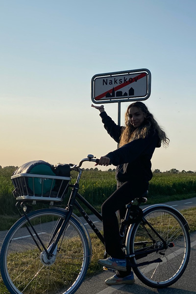 Noura standing with a bike