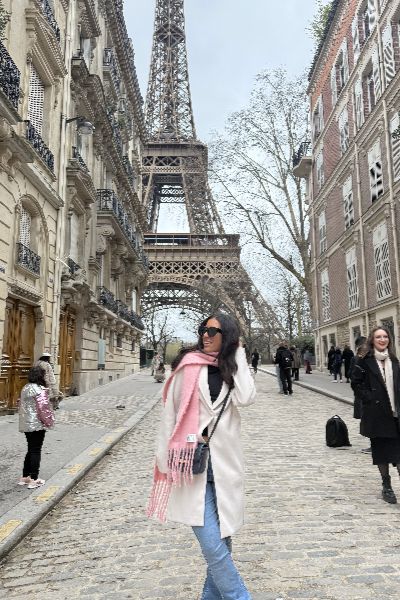 Ariana smiling in front of the Eiffel tower