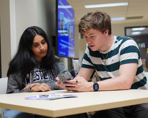 English Conversation Program. One student helping another student study