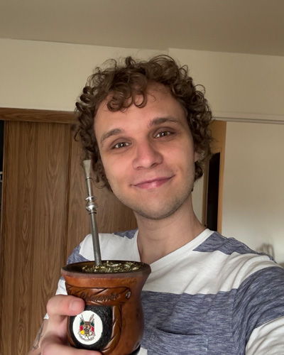 Carlos holding a traditional South American beverage from home