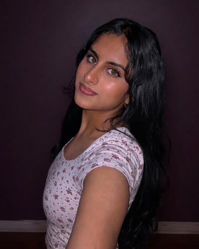 Hamsini in front of a purple backdrop showing off her Western pride